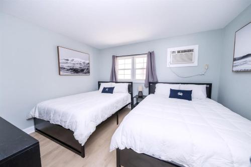 Dos camas en una habitación con paredes azules. en 6201 Ocean Ave, Unit 210 - The Nassau Inn, en Wildwood