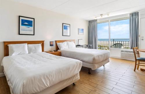 Una habitación de hotel con dos camas y balcón. en 6201 Ocean Ave, Unit 511 - The Nassau Inn, en Wildwood