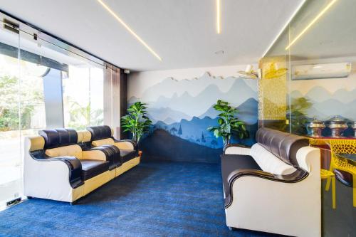 a waiting room with couches and a mural of mountains at Collection O Shamshabad Paradise in Shamshabad