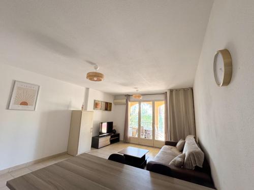 un salon avec un canapé et une télévision dans l'établissement Jolie T2 - Sierra Léone 218, à Canet