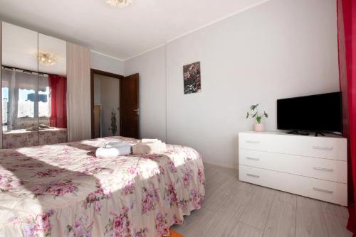 a bedroom with a bed with a dresser and a tv at Grazioso Bilocale vicino Bergamo in Seriate