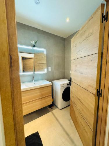 une salle de bain avec un lavabo et une machine à laver dans l'établissement Maison design pour 8 pers proche Paris et Disney, à Villiers-sur-Marne