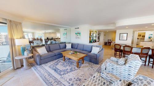 a living room with a blue couch and a table at Inlet Reef 609 in Destin