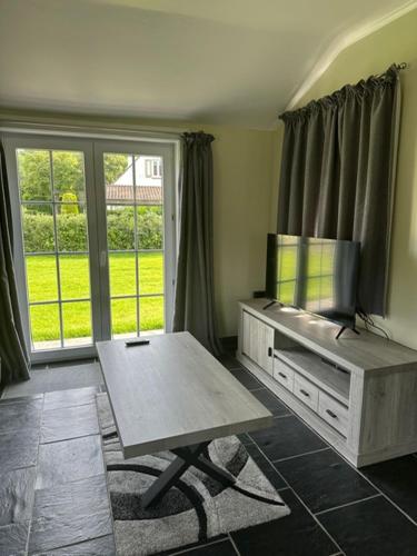 a living room with a table and a large window at Villa Angelina in De Panne
