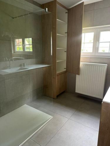 a large bathroom with a sink and a mirror at Villa Angelina in De Panne