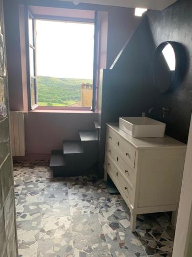 une salle de bain avec un lavabo et un escalier avec une fenêtre dans l'établissement Oppida Lussan, à Lussan