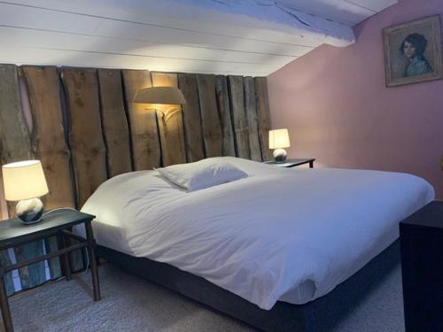 une chambre avec un grand lit blanc et deux lampes dans l'établissement Oppida Lussan, à Lussan
