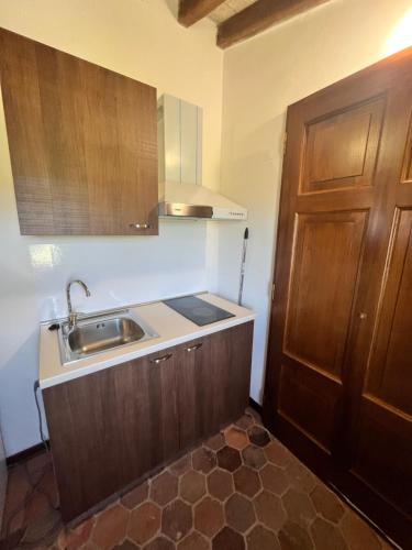 a kitchen with a sink and a wooden door at Casale San Francesco d'Assisi in Assisi