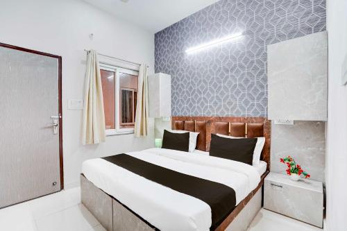 a bedroom with a large bed in a room at Townhouse Oak Vasundra Nagar in Rajod