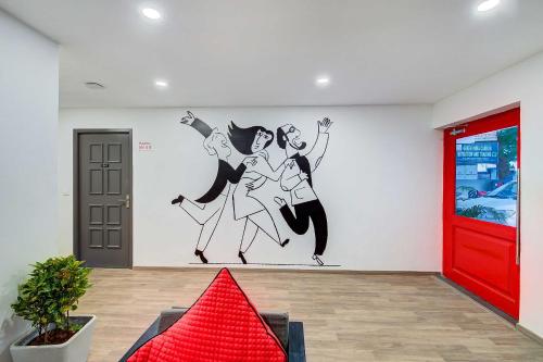 a wall mural in a room with a red door at Townhouse Oak T Nagar Chennai in Chennai