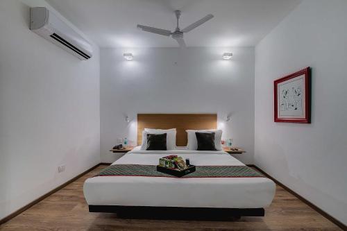 a bedroom with a large bed with a ceiling fan at Townhouse Oak T Nagar Chennai in Chennai