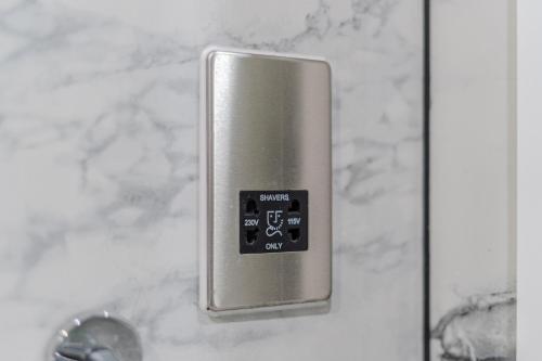 a close up of a bathroomaucet with a control panel at Ilford Hotel Goodmayes in Ilford