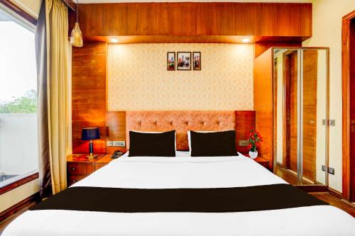 a bedroom with a large white bed and a window at Townhouse Oak Sector 47 Near Medanta in Gurgaon