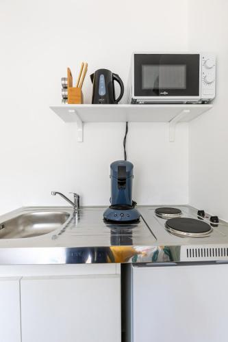 une cuisine avec une cuisinière et un micro-ondes dans l'établissement Charmant Studio Centre-Ville, à Strasbourg
