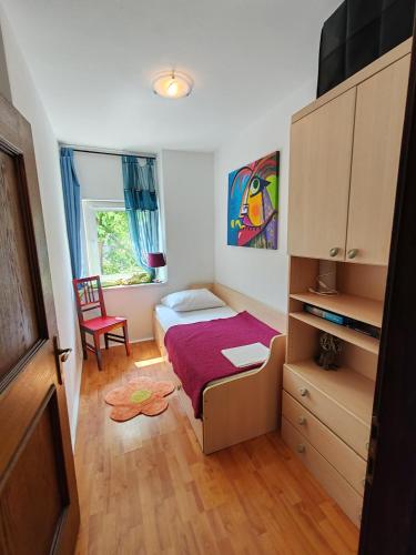 a small bedroom with a bed and a chair at Art Gallery House with a small relaxing pool in Crikvenica