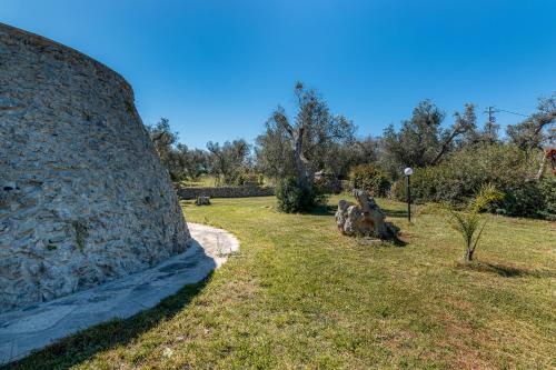 a large stone wall in a field of grass at Tenuta San Lorenzo in Otranto