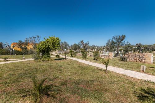 a path through a park with trees in a field at Tenuta San Lorenzo in Otranto