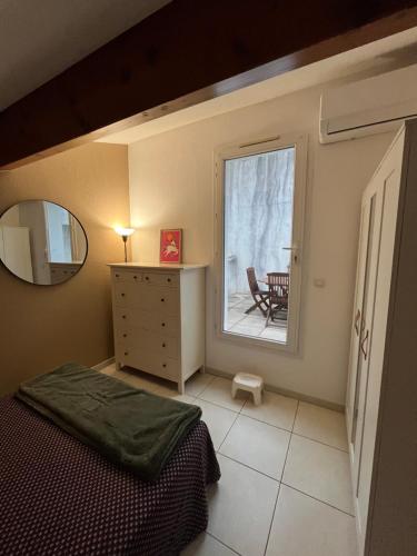 - une chambre avec un lit et une fenêtre avec une table dans l'établissement Appartement duplex la Ciotat, à La Ciotat