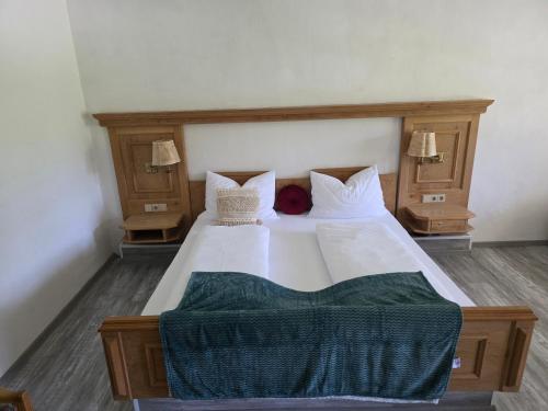 a bedroom with a large white bed with two lamps at Ferienwohnung Allgäu Natur & Spa in Wiggensbach