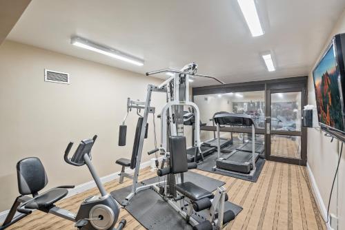 a gym with several tread machines in a room at Coratel Plus Suites Wichita West Airport in Wichita