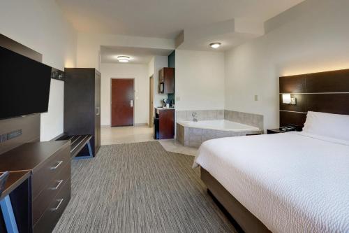 a hotel room with a bed and a bath tub at Holiday Inn Express Hotel & Suites- Gadsden by IHG in Gadsden