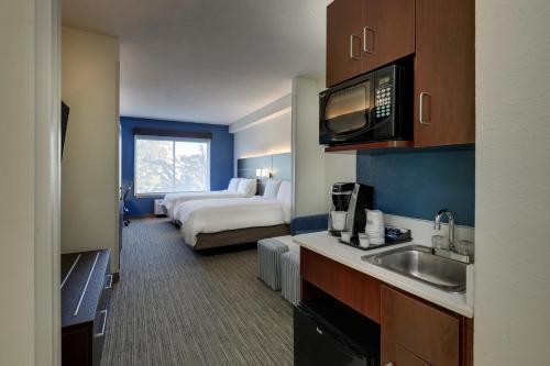 a hotel room with a bed and a kitchen with a sink at Holiday Inn Express Hotel & Suites- Gadsden by IHG in Gadsden