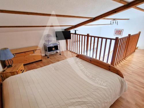 une chambre avec un grand lit dans une pièce dans l'établissement T3 mezzanine avec balcon, climatisation et parking - Quartier Villeroy, à Sète
