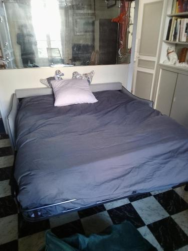 un grand lit dans une chambre avec une fenêtre dans l'établissement Studio de charme à Trouville sur mer., à Trouville-sur-Mer