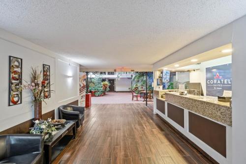 a lobby of a hotel with a reception desk and a lobby at Coratel Plus Suites Wichita West Airport in Wichita