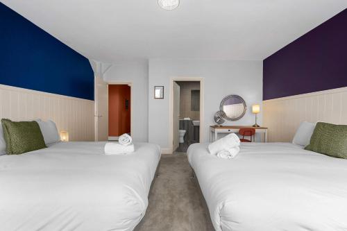 deux lits blancs dans une chambre aux murs bleus et blancs dans l'établissement Iconic Canal Street Apt by City SuperHost, à Manchester