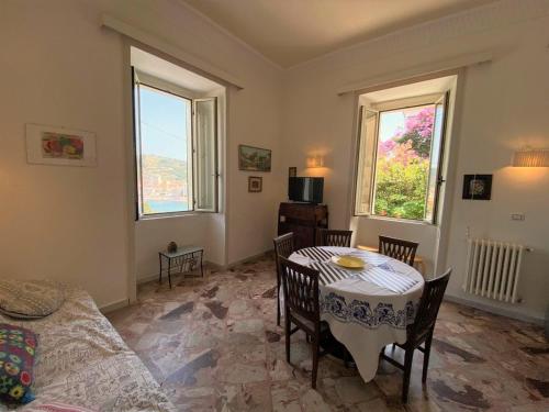 a living room with a table and chairs and two windows at Panoramic Apartments in Villa in Center "The Beach and The Cliff" 1 in Agropoli