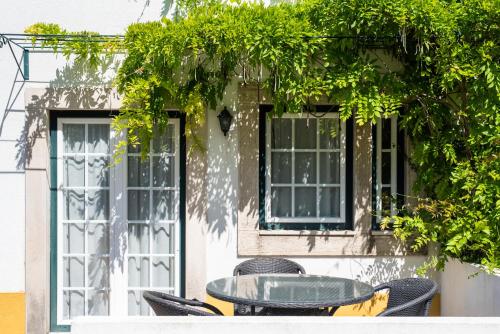 a table and chairs in front of a building at DOMA Portugal in Mafra