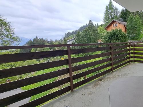 a wooden fence with a house in the background at Waldhaus - CharmingStay in Flumserberg