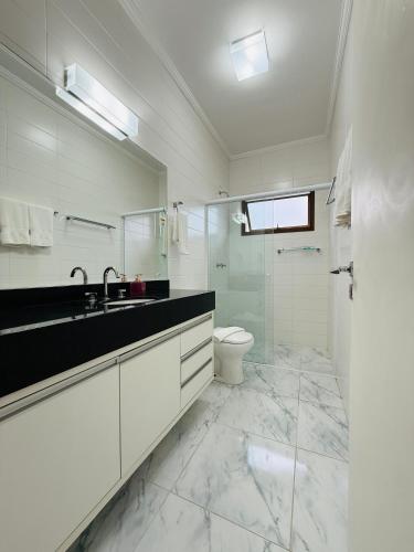 a white bathroom with a sink and a toilet at Boulevard Montreal in Monte Verde