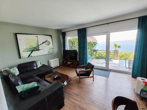 a living room with a couch and a large window at Art Gallery House with a small relaxing pool in Crikvenica