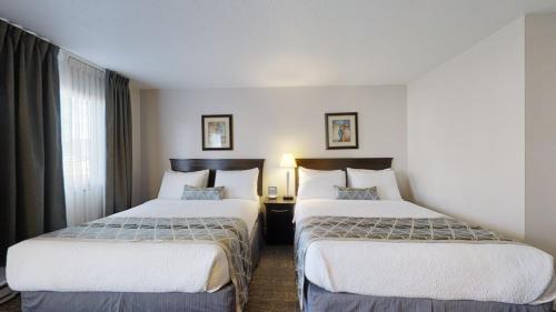 a hotel room with two beds and a window at Dilworth Inn Kelowna in Kelowna