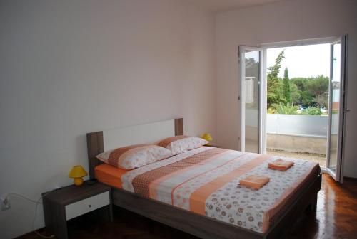 una camera con letto e porta scorrevole in vetro di Ante Carov Apartment a Verunić