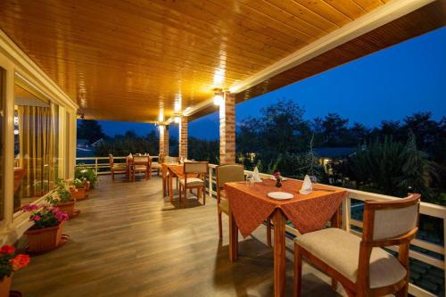 a patio with tables and chairs on a deck at night at The Orchard Retreat & Spa in Srinagar