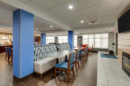 a dining room with tables and chairs and blue columns at Holiday Inn Express Hotel & Suites- Gadsden by IHG in Gadsden