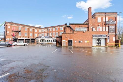 an empty parking lot in front of a brick building at Modern Self-Contained Studio in Dudley with Parking in Dudley