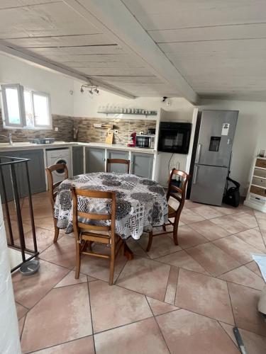 une cuisine avec une table et des chaises dans une pièce dans l'établissement Appartement 5 personnes village provençal du haut var claviers, à Claviers