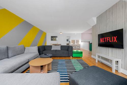 a living room with a couch and a tv at Iconic Canal Street Apt by City SuperHost in Manchester