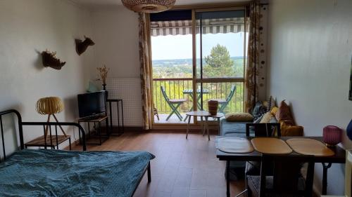 Cette chambre comprend un lit, une télévision et une fenêtre. dans l'établissement Sudio tout équipé avec balcon, à Montrichard