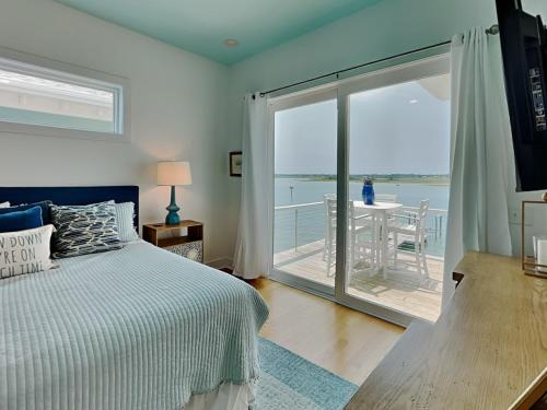 a bedroom with a bed and a view of the ocean at Channel 6 in Surf City