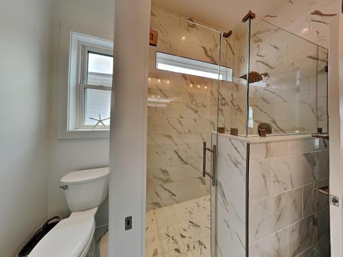 a bathroom with a toilet and a glass shower at Channel 6 in Surf City