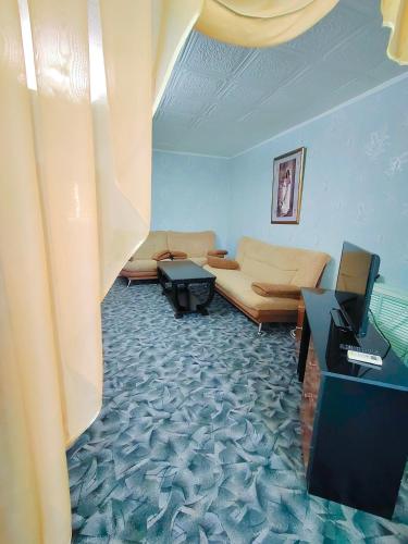 een woonkamer met een bank en een tafel bij Гостиница Зеленая in Aqtau