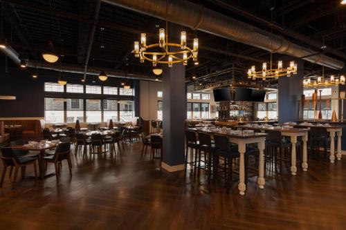 韦斯特切斯特Hotel Indigo West Chester - Downtown by IHG的有桌椅和吊灯的餐厅
