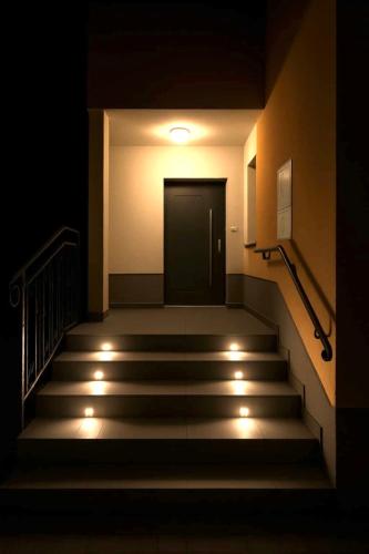 a dark hallway with stairs with a door and lights at Apartma Zala in Šmarje