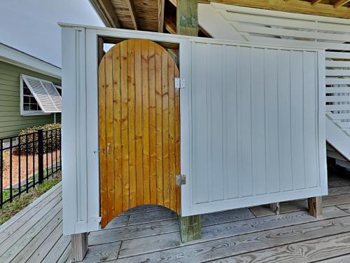 a gate on a deck with a wooden door at Channel 6 in Surf City