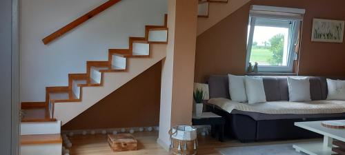 a living room with a couch and a staircase at Kuća za odmor Milan in Šarengrad